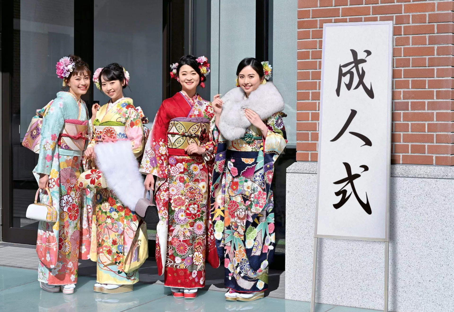 Young Japanese women posing outside a hall where a seijinshiki is being held.